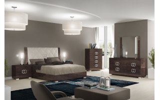 Status Prestige hálószoba magasfényű barna nyír színű család. Az ágykeret fejvége lehet fa vagy textilbőrrel fedett. A fém fogantyúk különleges formája adja az egyediségét ennek a bútorcsaládnak.